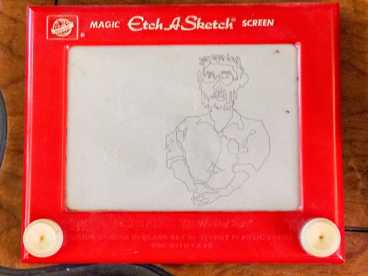 etch-a-sketch showing a messy doodle of a person with beard