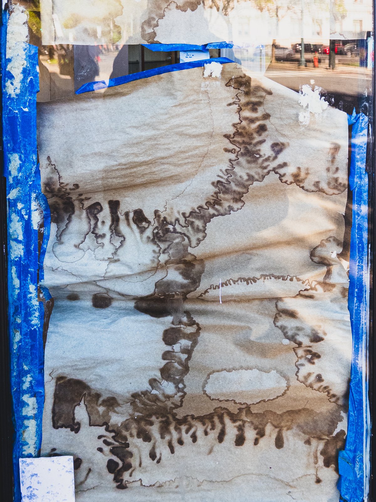 brown paper in a shop window with a strange pattern from water damage