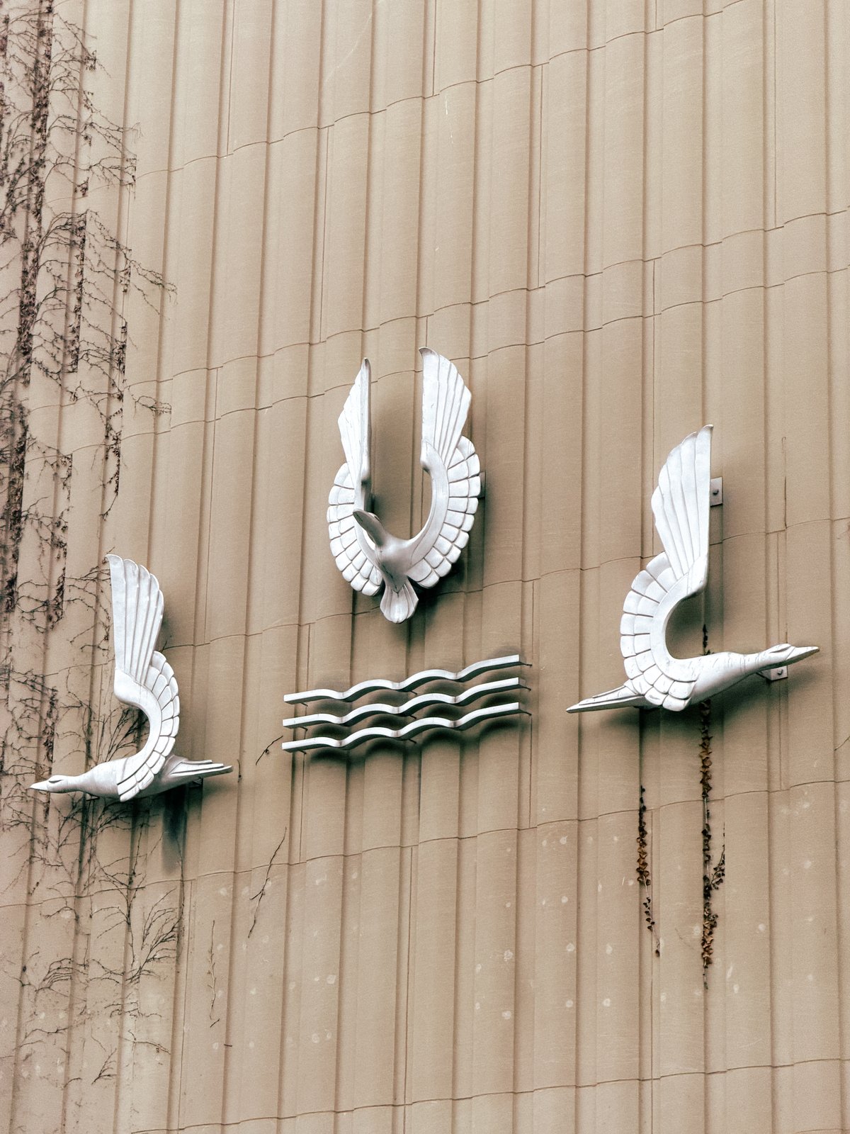 art deco metal bird statues on the side of a building