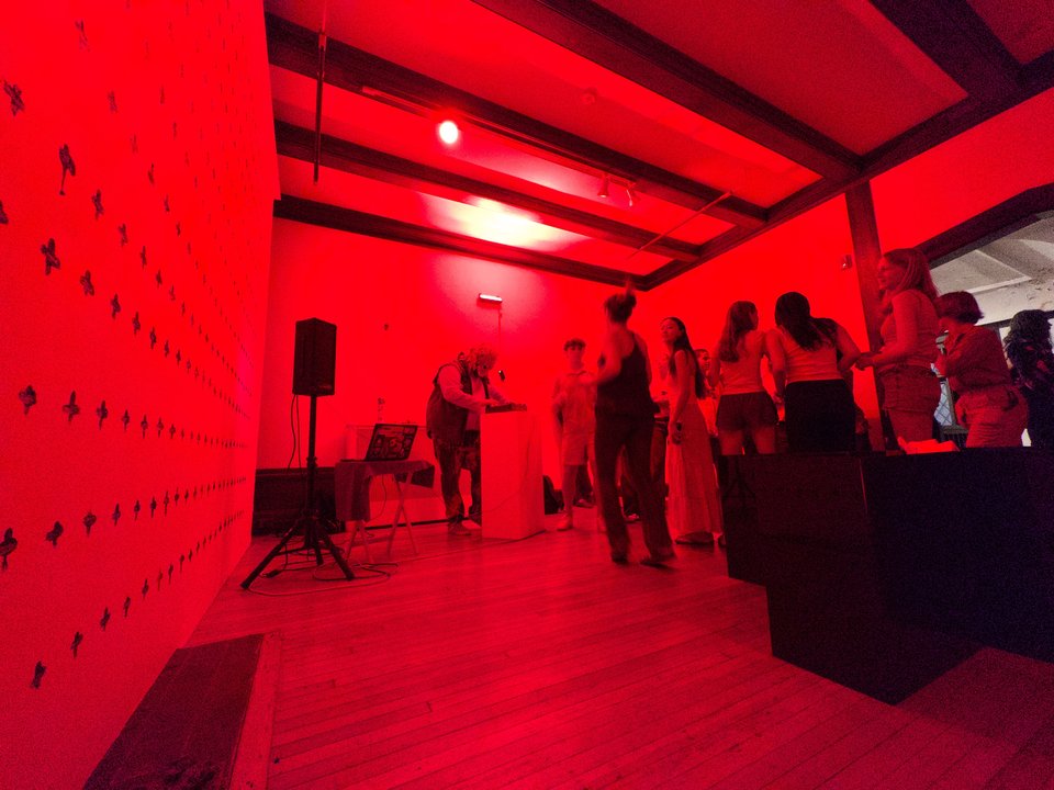 a room lit only with red light and some people dancing