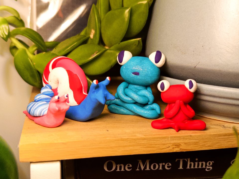 four small clay figures, two snails and two frogs