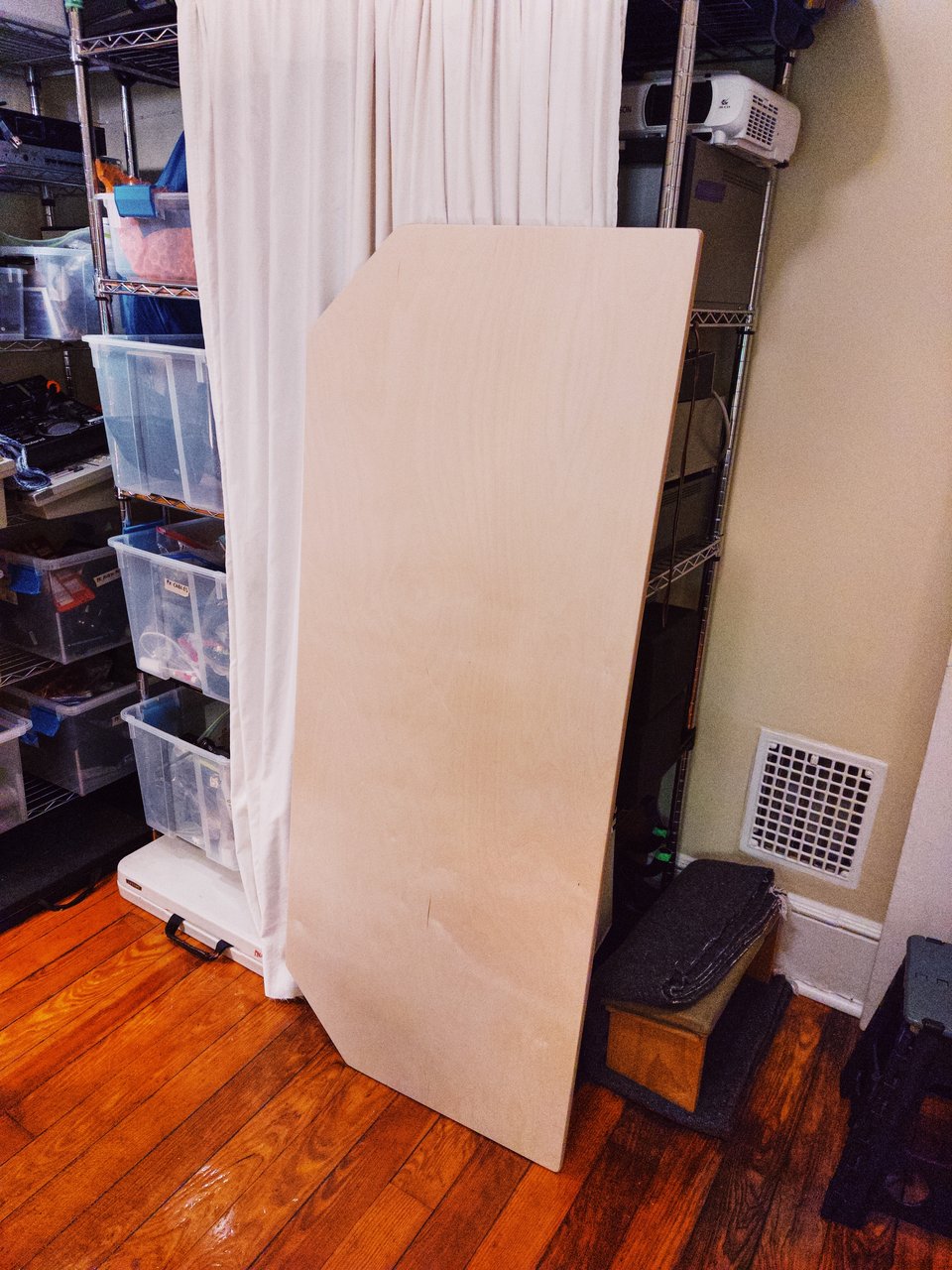 a piece of plywood leaning against a shelf