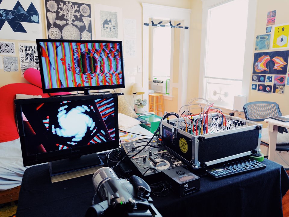 video equipment including a modular synth, two TVs, and a camera