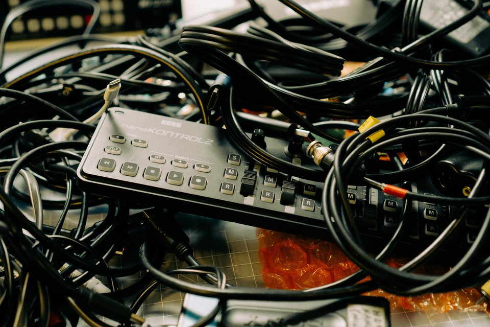 piles of cables and a midi controller