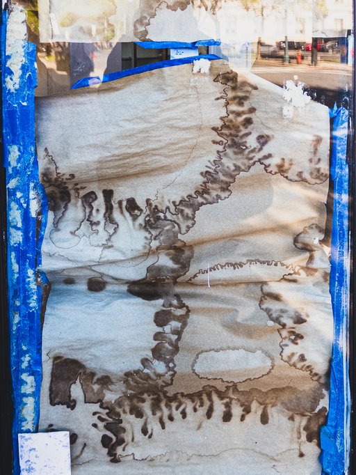 brown paper in a shop window with a strange pattern from water damage