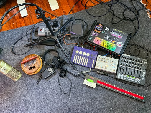a bunch of audio gear on a blanket on the floor