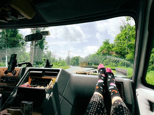 feet on the dashboard of a van with wood paneling accents