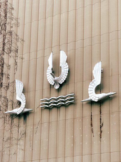 art deco metal bird statues on the side of a building